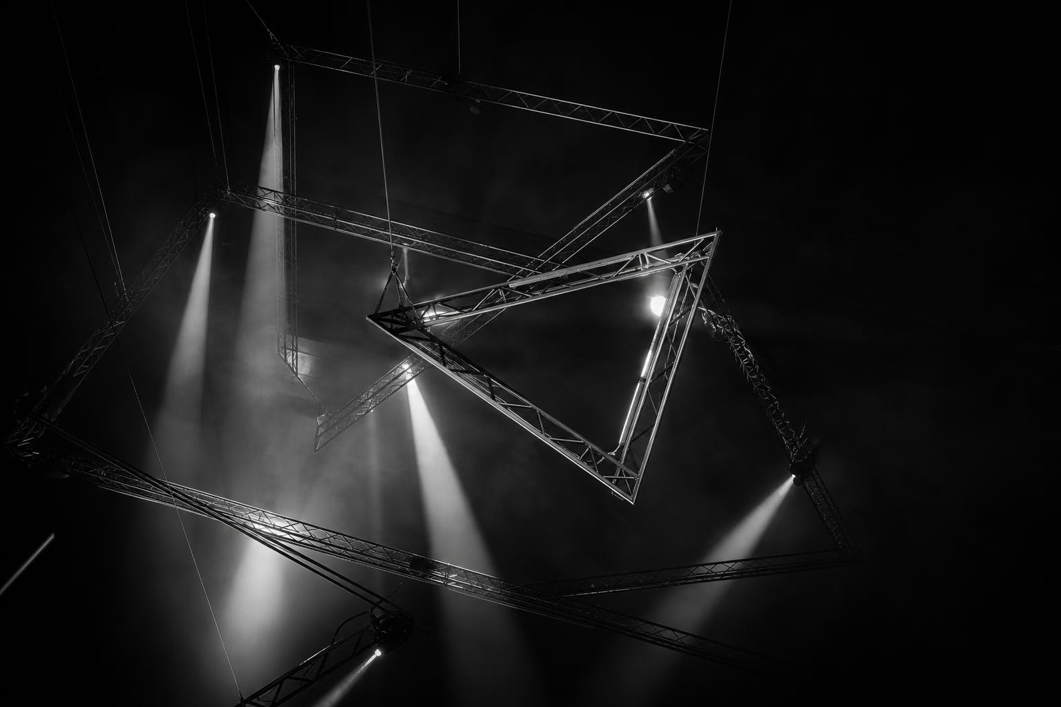 Massive convention hall with perfectly aligned seating and dramatic stage lighting, revealing the scale of complex event execution